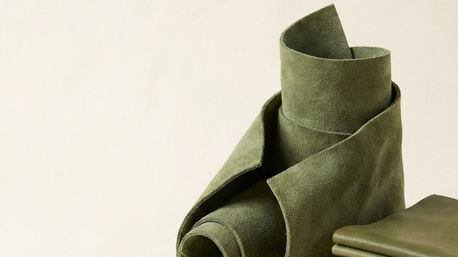 Rolled moss green suede and a stack of folded green leathers from the TL San Martín barefoot library