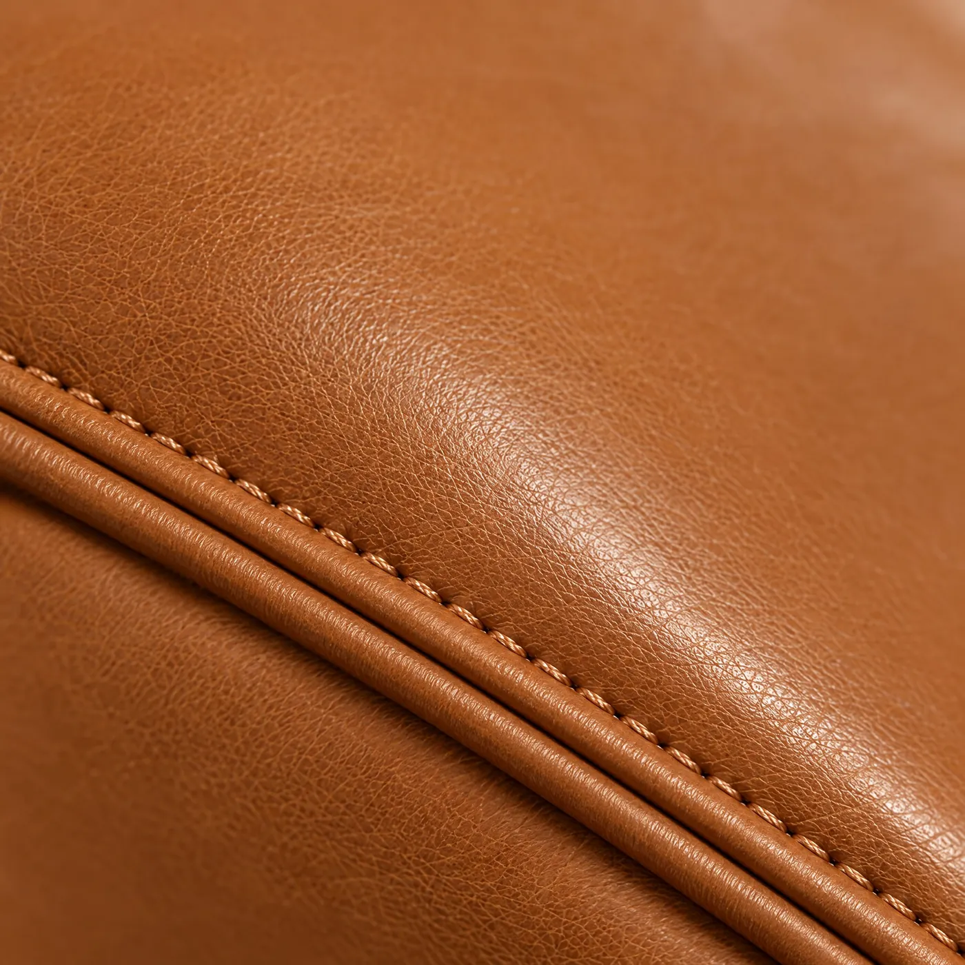 Stitching and edge detail on a cognac leather case